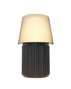 Kono Graphite table lamp by Lempori illuminated with warm white LED light on a white background.