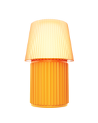 Kono Ochre table lamp by Lempori illuminated with warm white LED light on a white background.