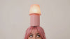 Model with pink hair balancing the Kono Blush table lamp by Lempori on her head in a studio photoshoot.